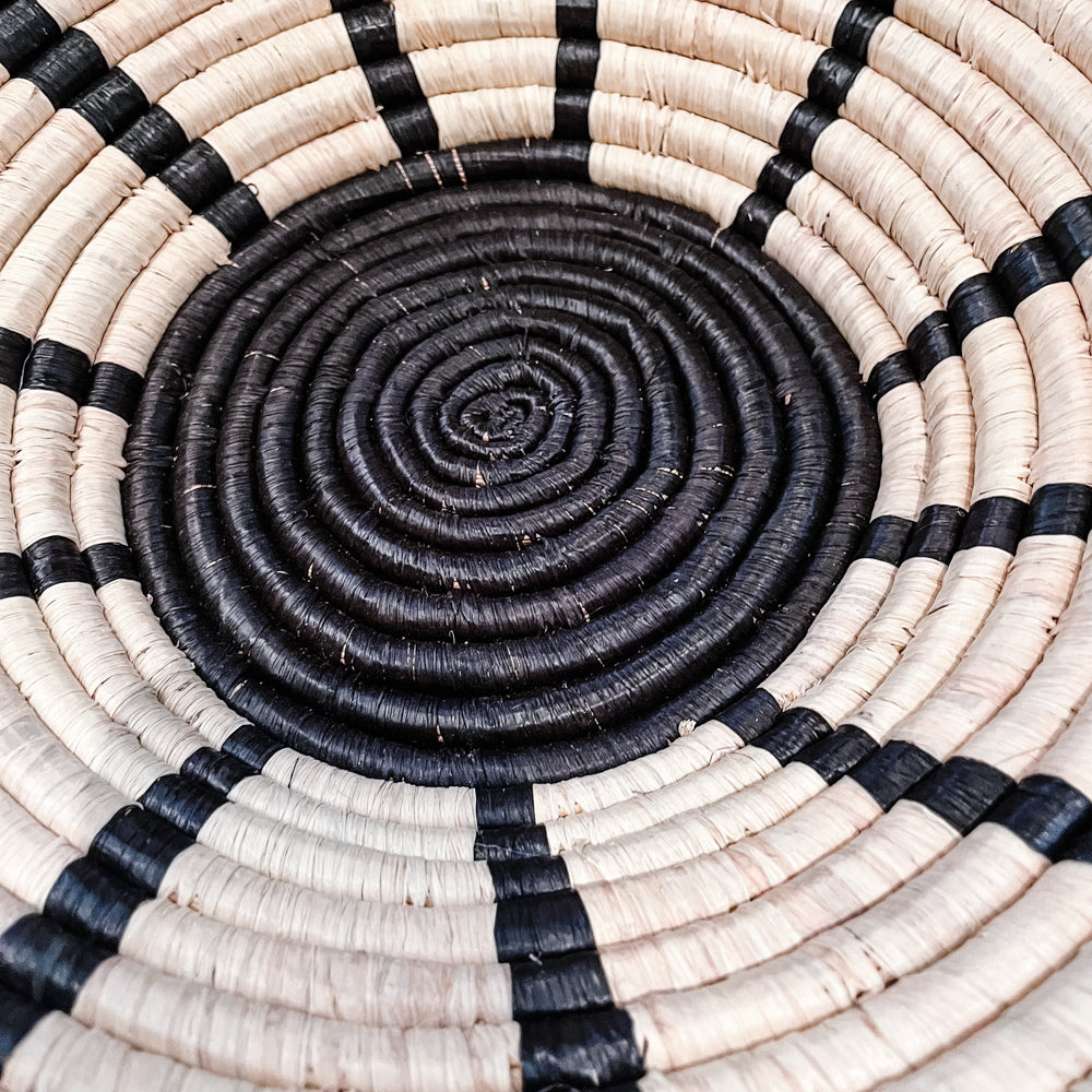 JustOne's natural basket with black stripes handwoven in Uganda