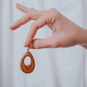 JustOne's dangling wooden earrings in the shape of a teardrop around 2 inches long, handcrafted in Kenya
