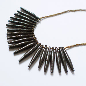 JustOne's necklace with long black paper beads dangling off, handcrafted in Uganda
