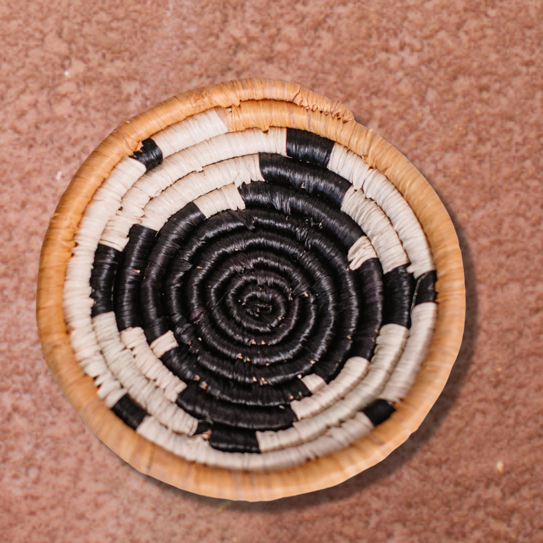 JustOne's small tan basket with black star and yellow border, handwoven in Uganda