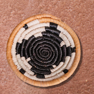 JustOne's small tan basket with black star and yellow border, handwoven in Uganda
