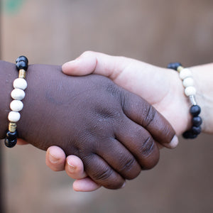 JustOne's bracelet with black and white beads made from ethically sourced bone and brass rings mixed in, handmade in Kenya