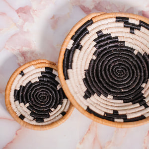JustOne's small tan basket with black star and yellow border, handwoven in Uganda