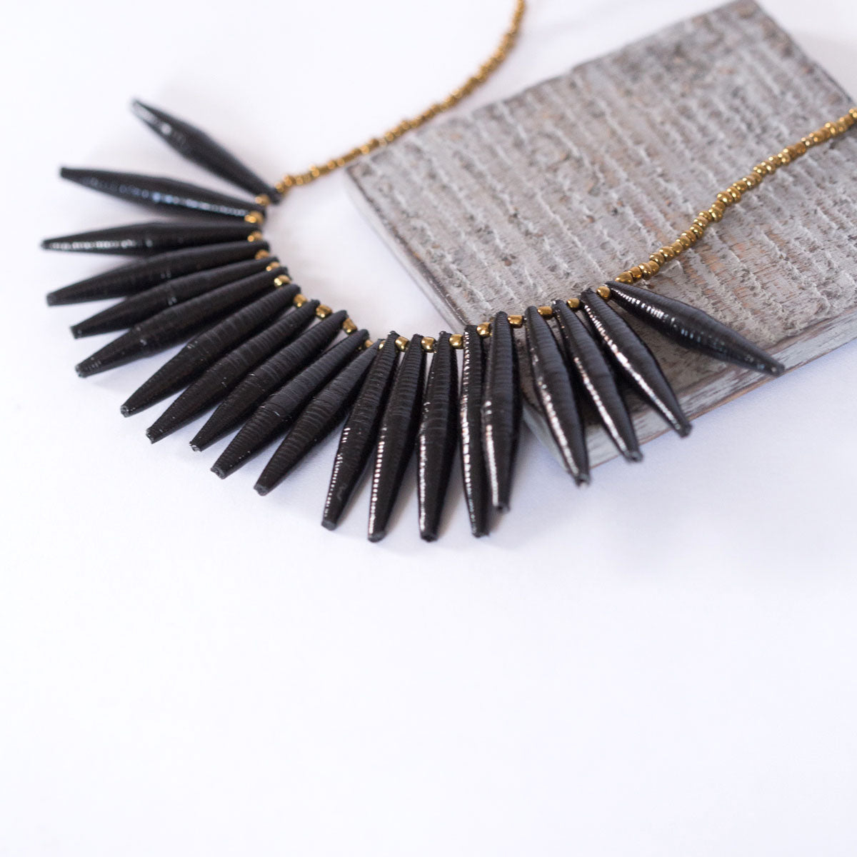 JustOne's necklace with long black paper beads dangling off, handcrafted in Uganda