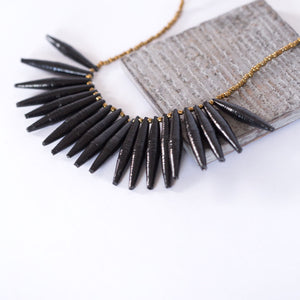 JustOne's necklace with long black paper beads dangling off, handcrafted in Uganda