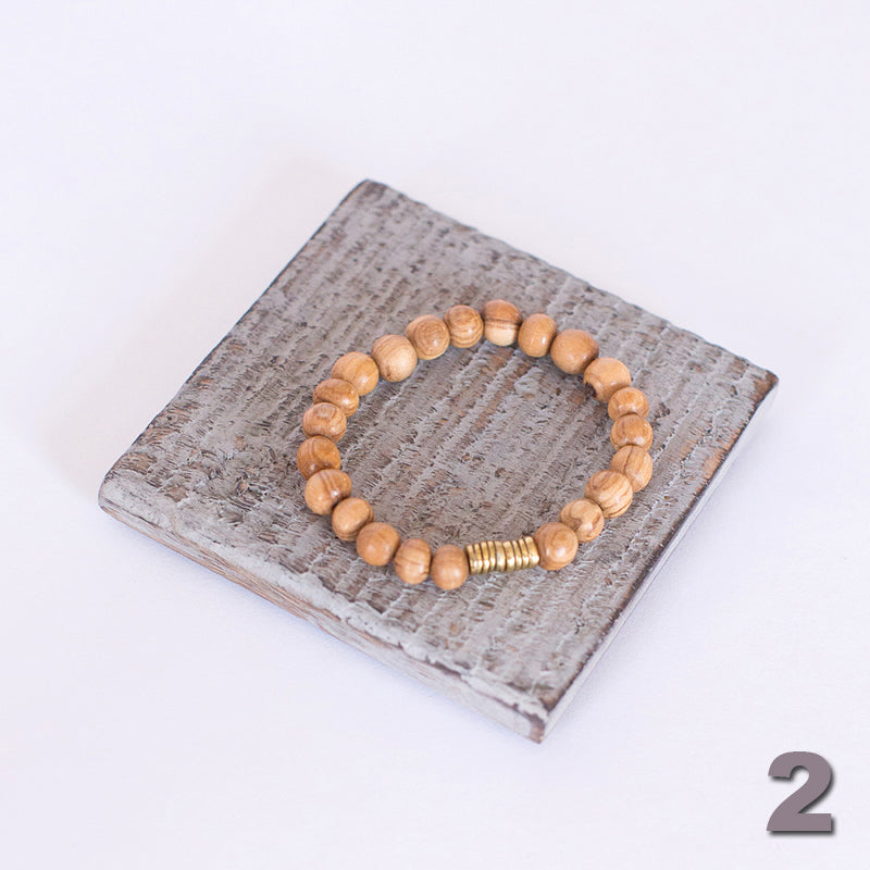 JustOne's stretch bracelet made with handcrafted wooden beads and a brass coil, handcrafted in Kenya