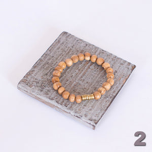 JustOne's stretch bracelet made with handcrafted wooden beads and a brass coil, handcrafted in Kenya