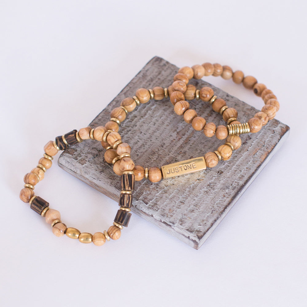 JustOne's stretch bracelet made with handcrafted wooden beads and brass rings, handcrafted in Kenya