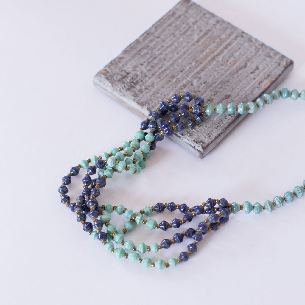 JustOne's paper bead necklace in teal and navy, handcrafted in Uganda