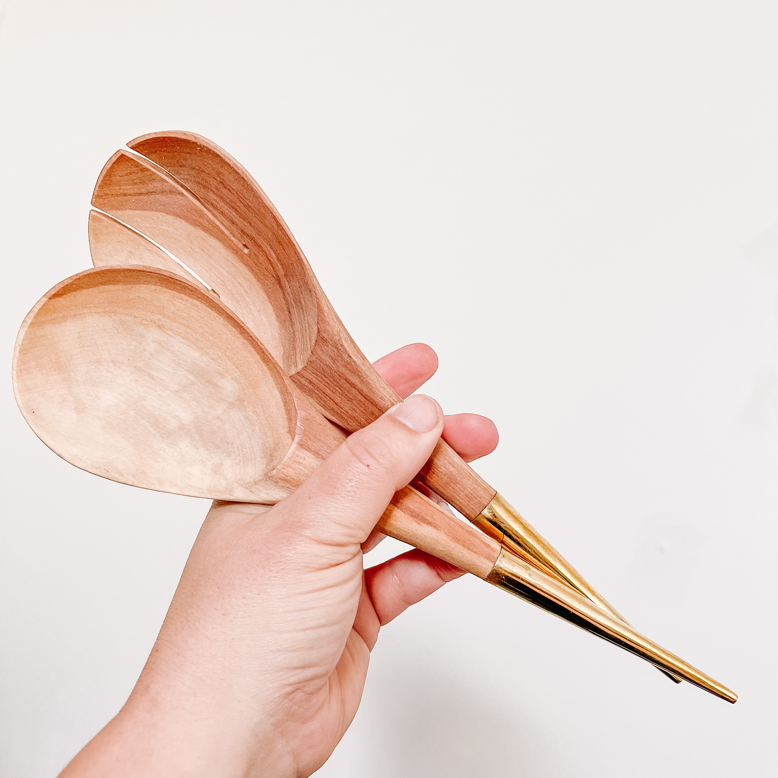 JustOne's handcrafted wooden salad spoons with a handle made of brass that comes to a point, made in Kenya