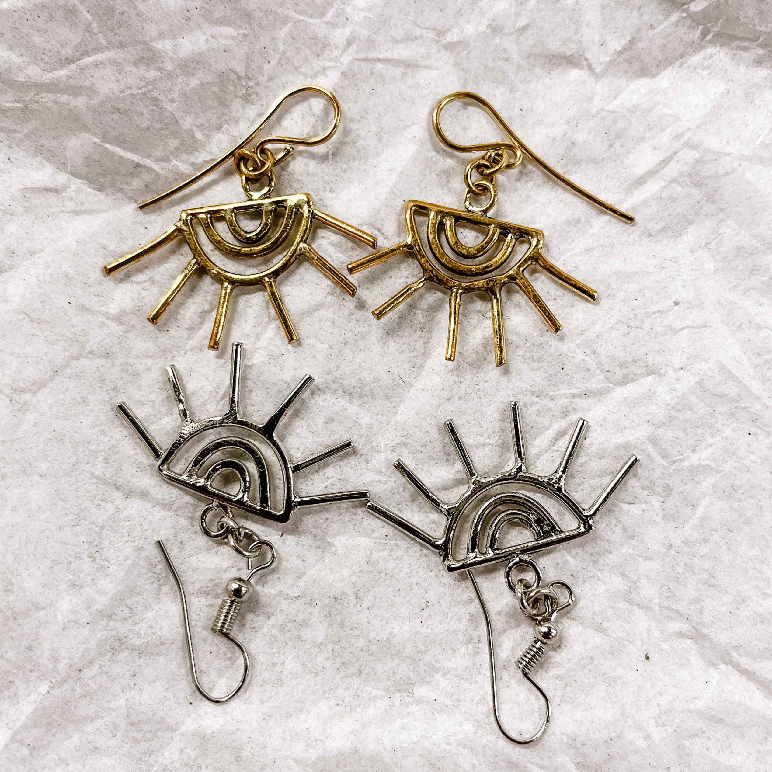 JustOne's brass and silver eye shaped earrings with eyelashes sticking out of the earring, handcrafted in Kenya