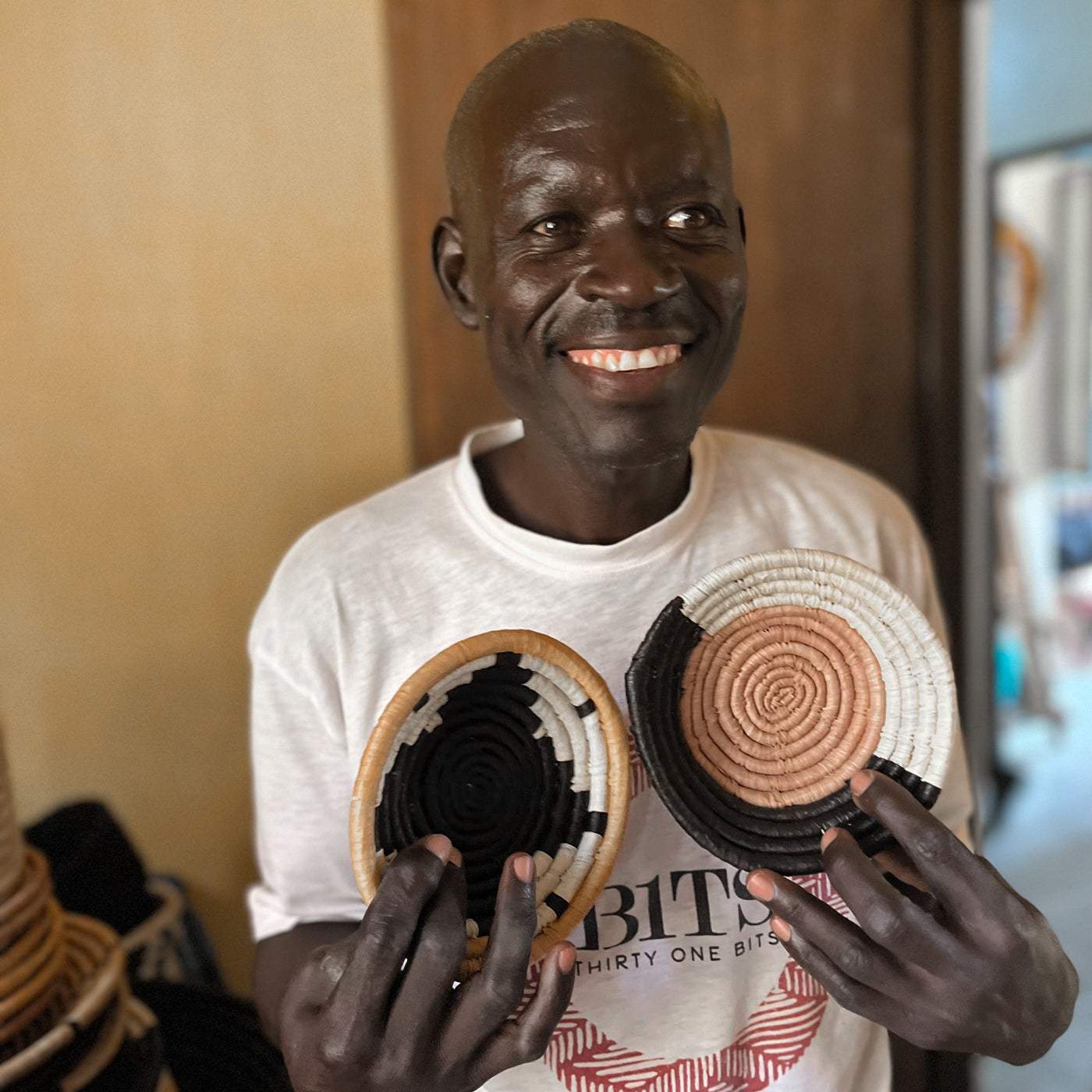 JustOne's small tan basket with black and natural border, handwoven in Uganda