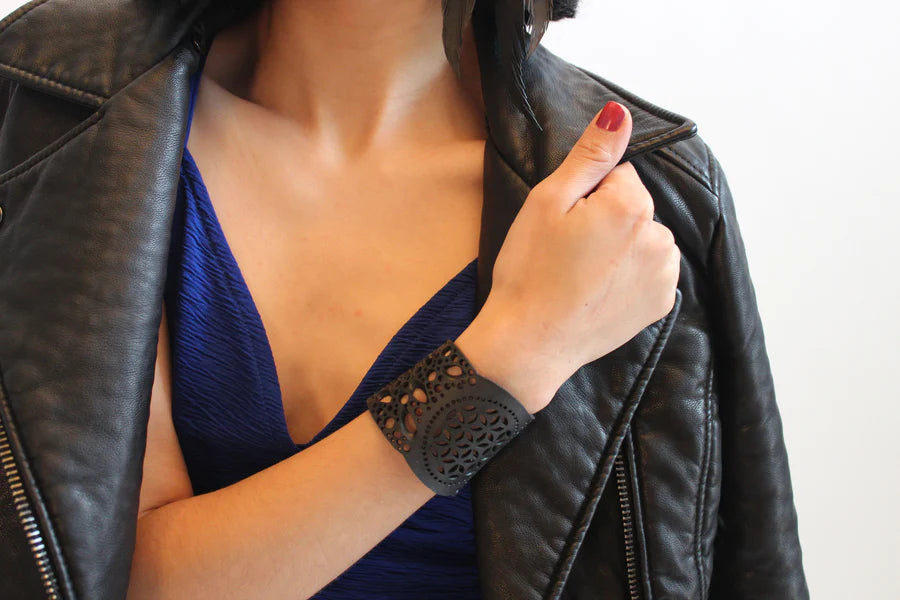 JustOne's black rubber bracelet with intricate detailed holes to make a flower like design handmade from recycled materials