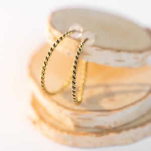 JustOne's brass hoops that has a twist design handcrafted in Kenya