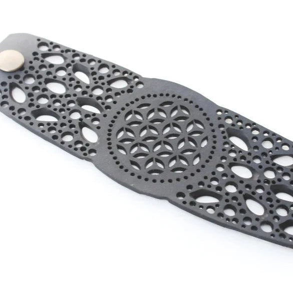 JustOne's black rubber bracelet with intricate detailed holes to make a flower like design handmade from recycled materials