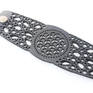 JustOne's black rubber bracelet with intricate detailed holes to make a flower like design handmade from recycled materials